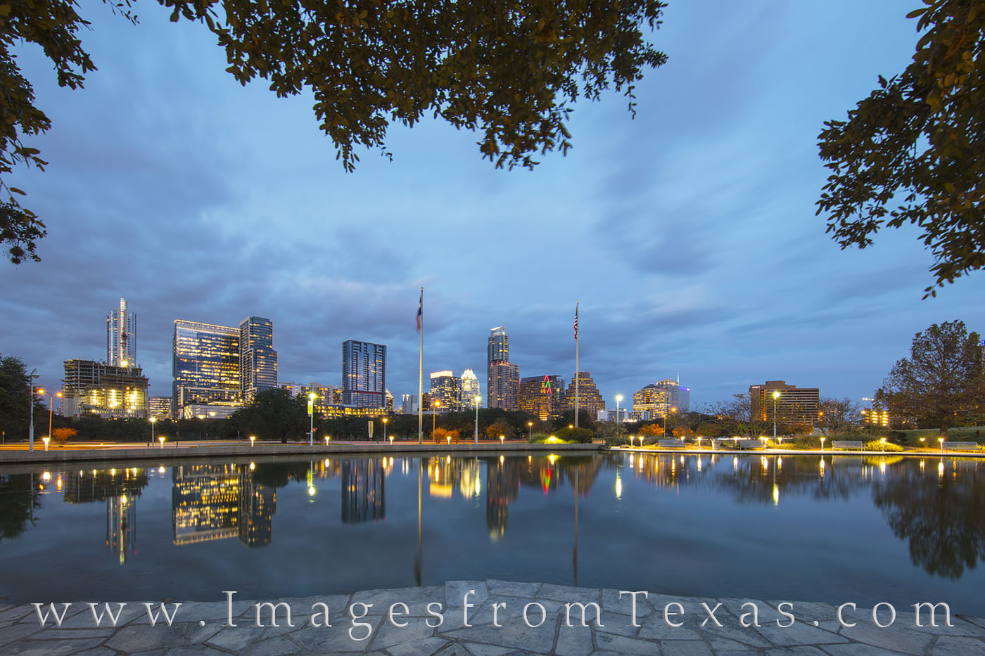 Austin Skyline December Evening 3 The Austin skyline rises into a cold December evening as reflections of the high rises shimmer in the still water near the Long...