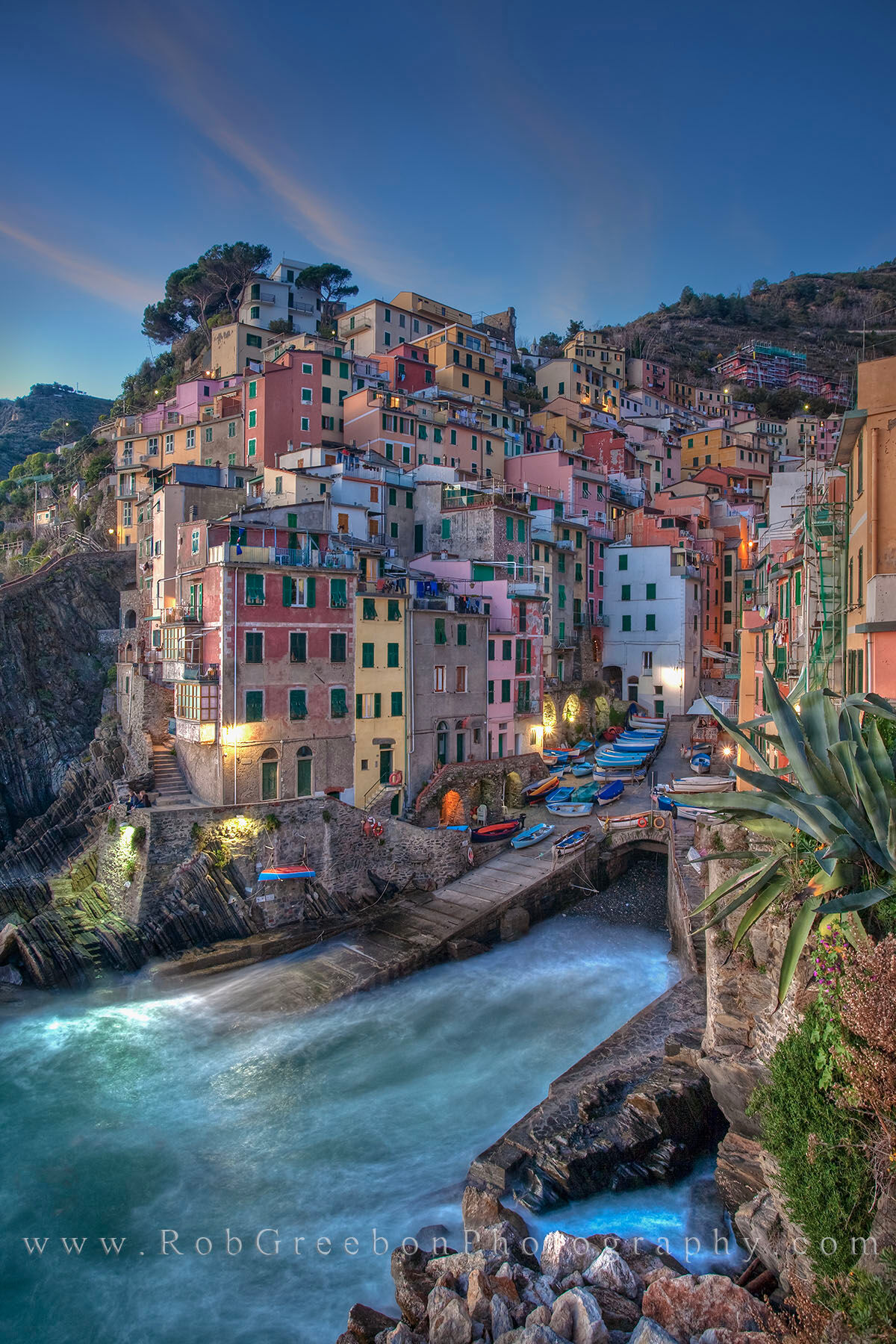 Cinque Terre, Italy - Riomaggiore Evening 1 The Cinque Terre fishing village of Riomaggiore prepares for the night as the lights begin to turn on and the sun sets in the...