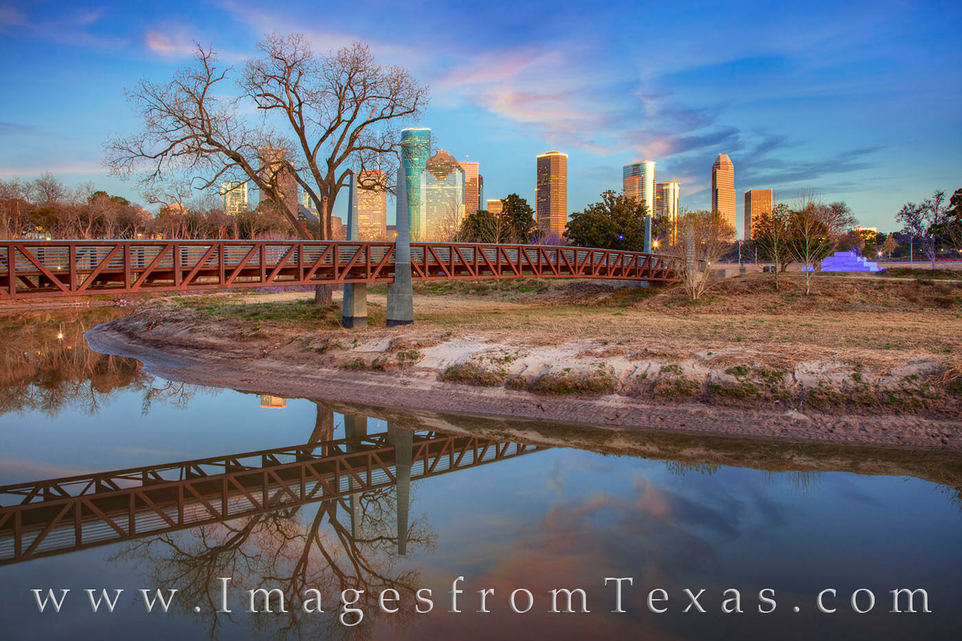 Houston Skyline on a Winter Evening 205-1-3 A pastel sky fades to evening over Buffalo Bayou and the Carruth Pedestrian Bridge. In the distance, the high rises of Texas'...