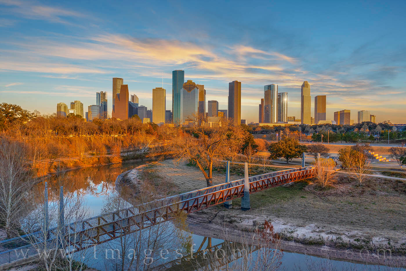 Winter Sunset over Buffalo Bayou 206-1 Carruth Pedestrian Bridge spans Buffalo on a cold winter's night near downtown Houston. The sun's rays were low, shading the...